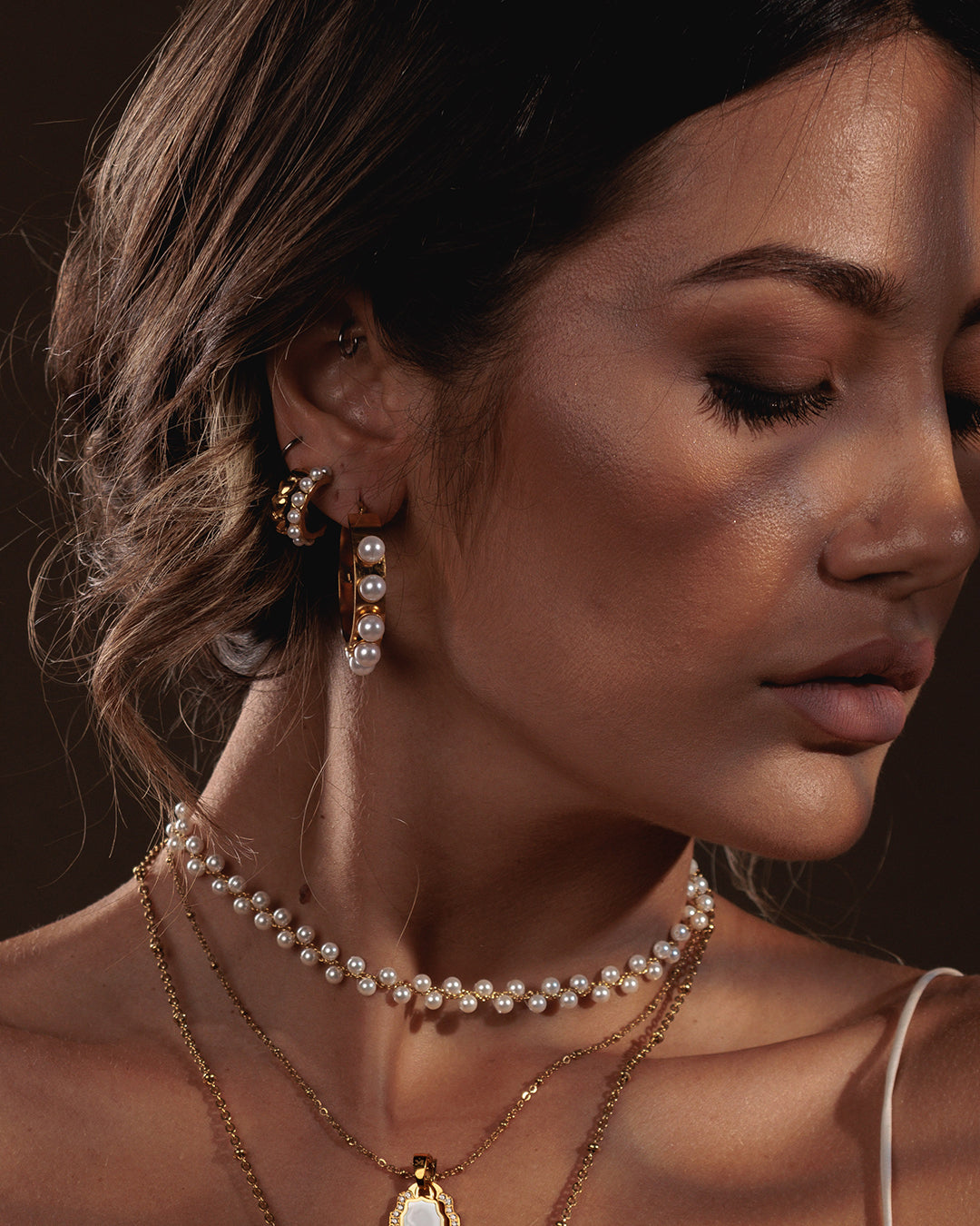 Model wearing a pearl choker and pearl hoop earrings